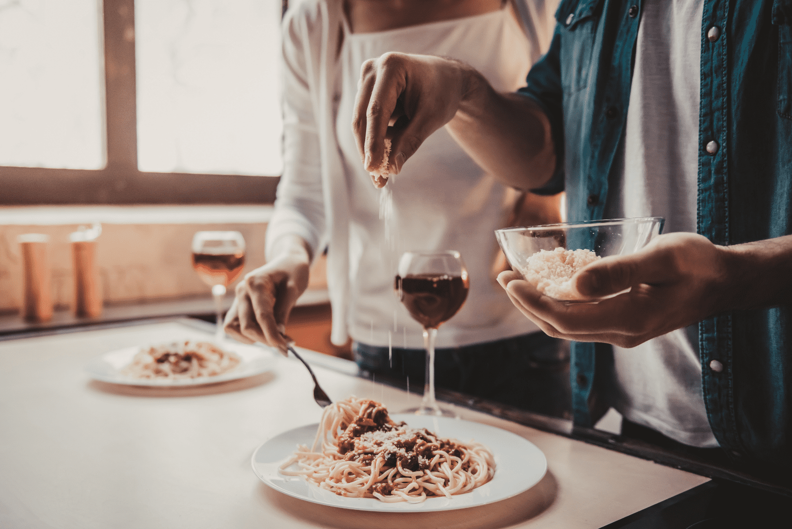 Couple with dishes of pasta and red wine